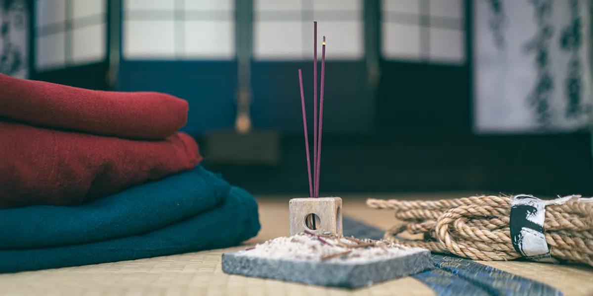 Custom linen garments, incense, and natural hemp rope arranged on tatami mats in the AIDA METHOD studio in Tokyo.